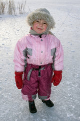 Bad Buchau  ein Kind steht in dicker Winterkleidung auf dem zugefrorenen Federsee