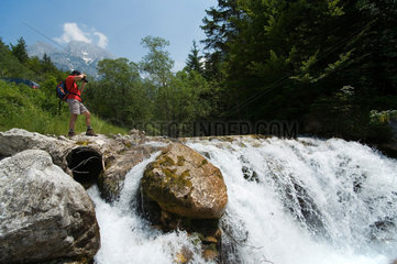 Kobarid  Mann fotografiert einen Wasserfall