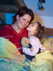 Berlin  Mutter und Tochter sitzen im Bett