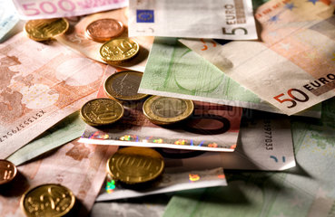Euromuenzen auf durcheinander liegenden Euroscheinen in verschiedenen Nennwerten