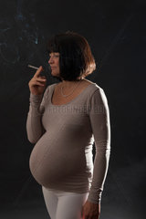 Freiburg  Deutschland  eine schwangere Frau mit einer brennenden Zigarette