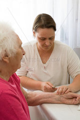 Mainz  eine Pflegerin untersucht eine aeltere Frau
