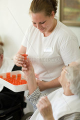 Mainz  eine Pflegerin verteilt die Medikamente am Mittagstisch
