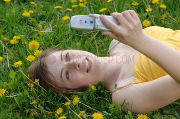 Frau schreibt eine SMS mit ihrem Handy