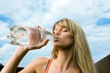 Berlin  Frau trinkt Wasser aus einer Flasche