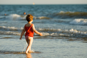 Spanien  kleines Maedchen laeuft ins Wasser  Matalascanas Strand in Huelva