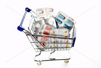 Einkaufswagen gefuellt mit Blisterpackungen von Medikamenten
