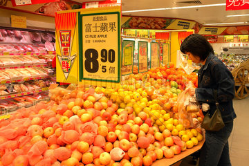 Hong Kong  Frau kauft Aepfel in einem Supermarkt