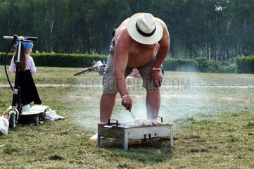 Berlin  ein Mann grillt im Park