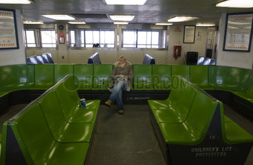 Junge Frau im leeren Innenraum der Staten Island Ferry