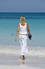 Junge Frau geht am Strand spazieren  Bahamas