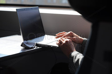 Berlin  Deutschland  eine Frau bedient ein Laptop waehrend einer Zugfahrt