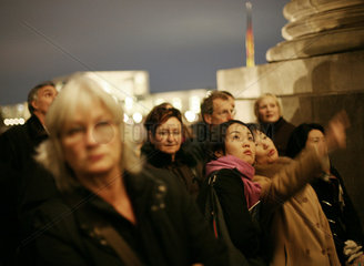 Menschen warten vor dem Haupteingang des Reichstages