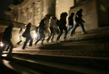 Jugendliche rennen die Treppe vor dem Haupteingang des Reichstages hinauf