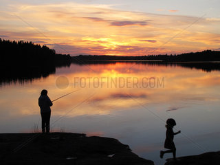 Silvkoparen  Schweden  eine Frau und ein Maedchen am Ufer eines Sees