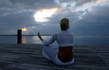 Junge Frau meditiert im Sonnenuntergang  Bahamas