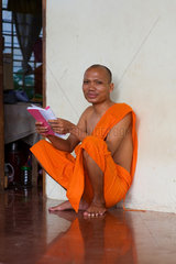 Phnom Penh  Kambodscha  ein buddhistischer Moench mit einem Buch