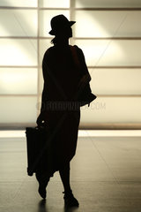 Berlin  Deutschland  Silhouette einer eleganten Frau mit Hut und Koffer