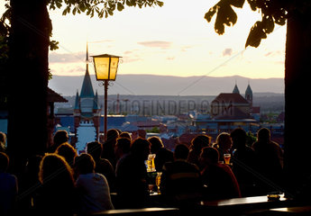 Freiburg im Breisgau  Deutschland  Menschen sitzen abends in einem Biergarten