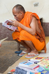 Phnom Penh  Kambodscha  ein buddhistischer Moench liest in einem Buch