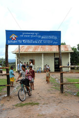Pum Chikha  Kambodscha  kambodschanisch  Maedchen auf einem Fahrrad vor einer Schule