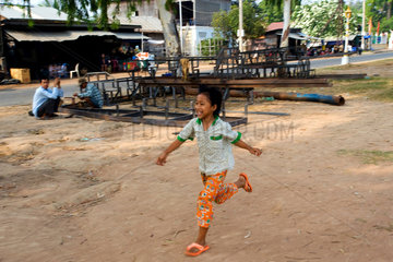 Kompong Thom  Kambodscha  ein Maedchen rennt durch die Strasse