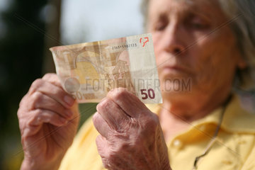Berlin  Deutschland  die Haende einer Rentnerin mit einem Euroschein