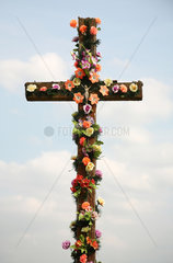 Wadol  Weissrussland  ein Kreuz geschmueckt mit Plastikblumen