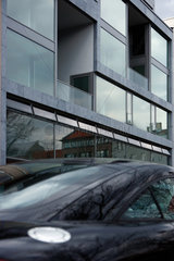 Berlin  Deutschland  Neubau mit grossen Fenstern  davor parkt ein schwarzes Coupe