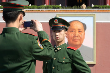 Peking  Soldat laesst sich vor Mao-Portraet fotografieren