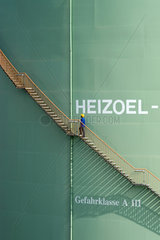 Schoenefeld  Deutschland  ein Mann steigt eine Treppe an einem Heizoeltank hinauf