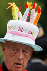 Ascot  Grossbritannien  Mann traegt einen Hut in Form einer Geburtstagstorte
