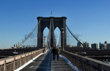 Die weltberuehmte Brooklyn Bridge in New York im Winter mit Fussgaengern