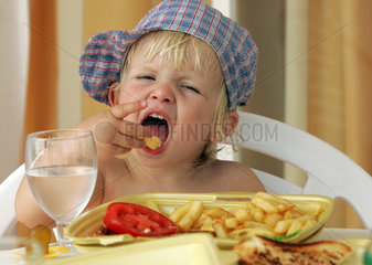 Pajara  ein kleines Kind isst Pommes Frites