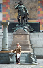 Altdorf  Schweiz  ein aelterer Mann steht vor dem Wilhelm Tell Denkmal