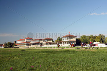 Iffezheim  Reiter und Pferde beim Training am Morgen vor den Tribuenen der Galopprennbahn