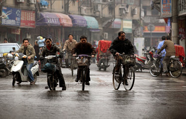 Shanghai  Fahrradfahrer auf regennasser Strasse