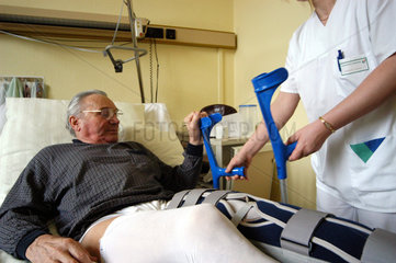 Patient beim ersten Aufstehen nach einer Knieoperation