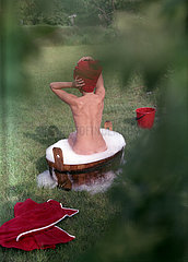 Strausberg  Deutsche Demokratische Republik  Frau badet im Garten in einem Waschzuber