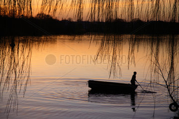 Potsdam  Silhouette eines Jungen in einem Boot in der Abendsonne