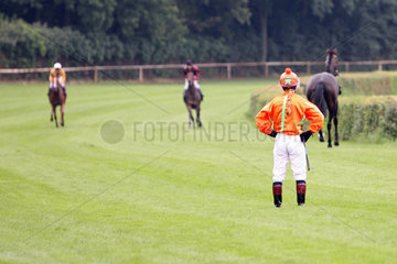 Hoppegarten  Deutschland  Jockey schaut seinem Pferd hinterher