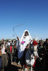 Mangudo  Aethiopien  Frau reitet auf einem Muli zur Schuleinweihung