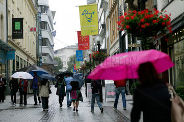 Luxemburg  Passanten mit Regenschirmen in der Rue de la Poste