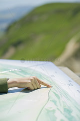 Child's hand touching map at scenic overlook