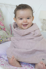 Baby wrapped in a towel  smiling  portrait