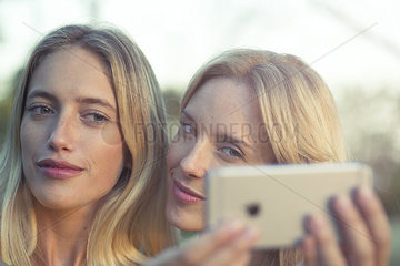 Women posing together for smartphone selfie