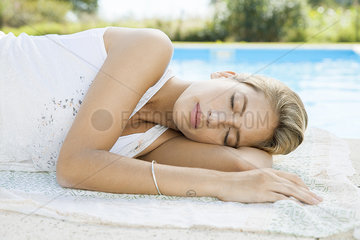 Woman resting at poolside with eyes closed
