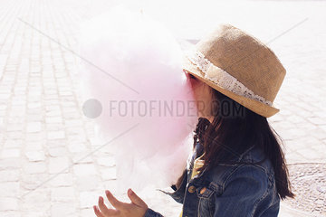 Little girl burying her face in cotton candy