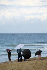 Westerland  Deutschland  Menschen mit Regenschirm am Strand