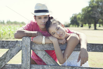 Young couple learning against wooden fence  portrait
